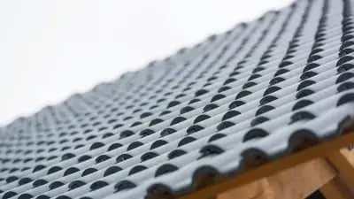 Close-up of a textured, wavy roof tile pattern in gray, highlighting its unique design and materials.