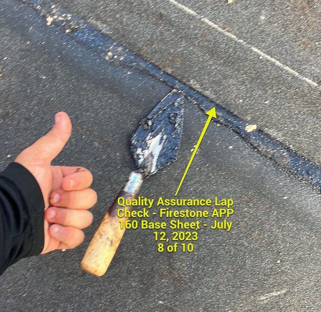 An inspector on the roof is doing a quality assurance check.
